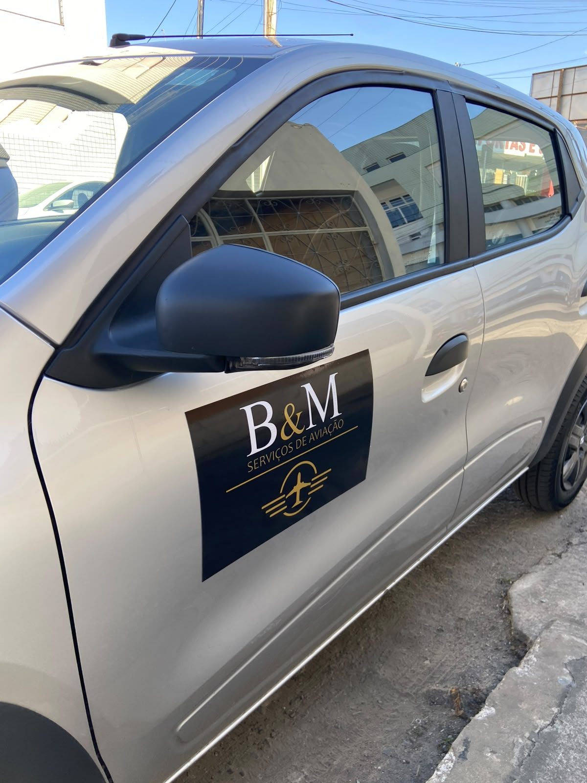 Porta do carro da B&M com a logo da empresa